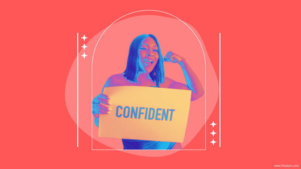 A confident woman smiling and flexing her arm while holding a sign that says "Confident," symbolizing self-love and confidence.